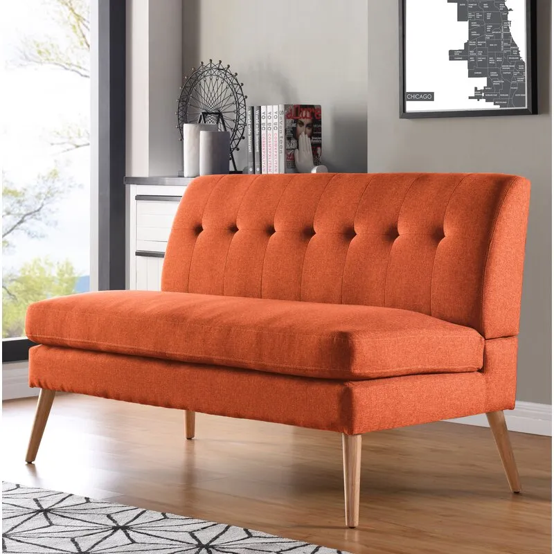 Interior inspiration — burnt-orange tufted mid-century settee with wooden legs in a styled living space