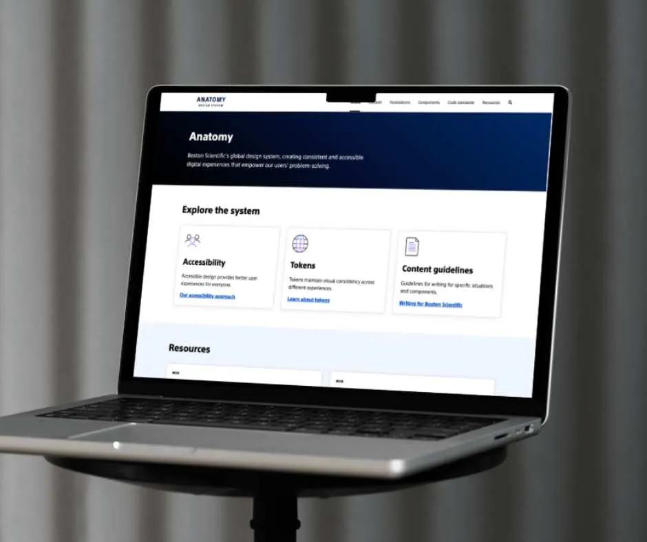Laptop showing the Anatomy design system site with Accessibility, Tokens and Content guidelines cards under 'Explore the system'